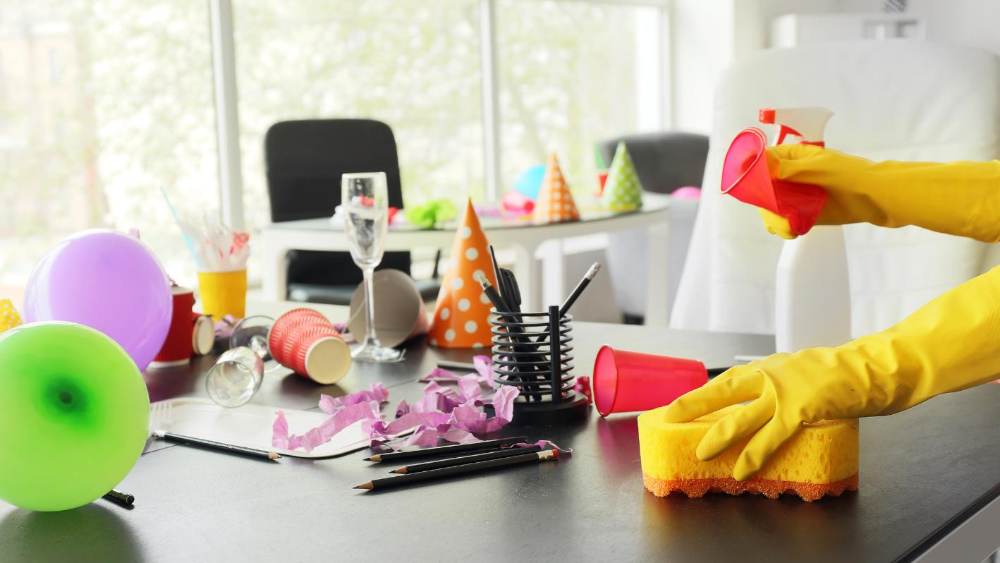 A person in yellow gloves cleaning a table